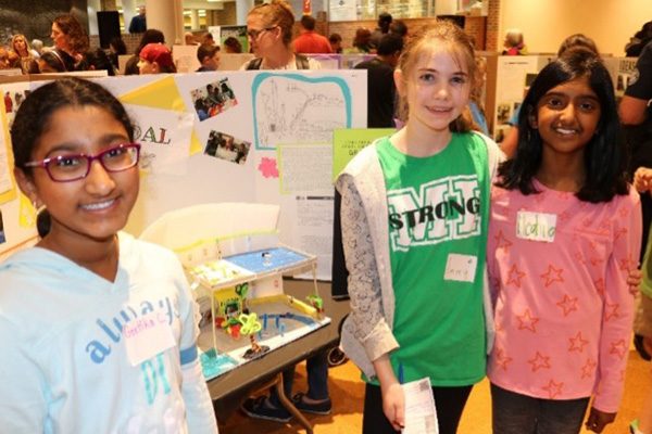 Design Lab students standing in front of a project